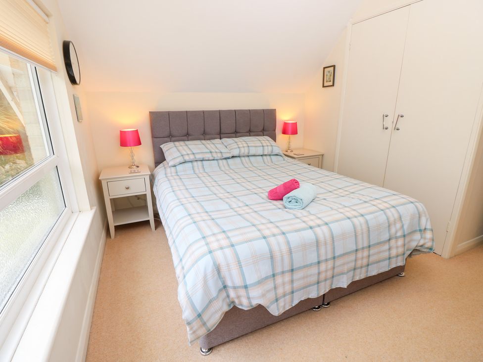 A bedroom with a bed and two nightstands at Tall Timbers in Ventnor