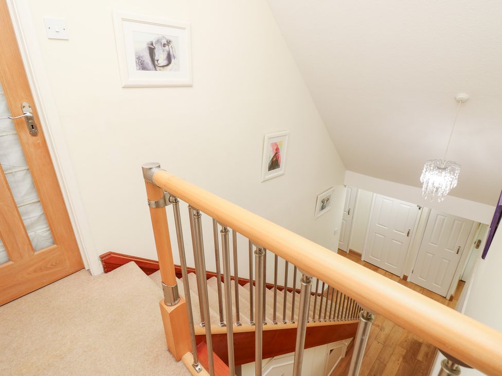 A staircase leading to an upper level in a hallway at Tall Timbers in Ventnor