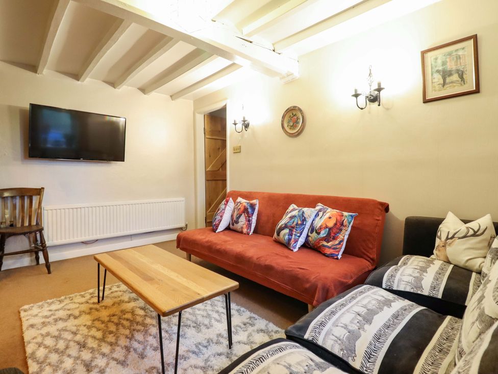 A living room with a sofa, coffee table and television at Bryn Y Garreg - The Wireless Free Farm (No Tech!) Y Trallwng