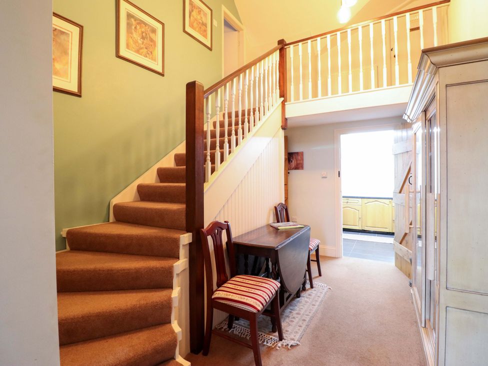A hallway with a staircase and table at Bryn Y Garreg - The Wireless Free Farm (No Tech!) Y Trallwng