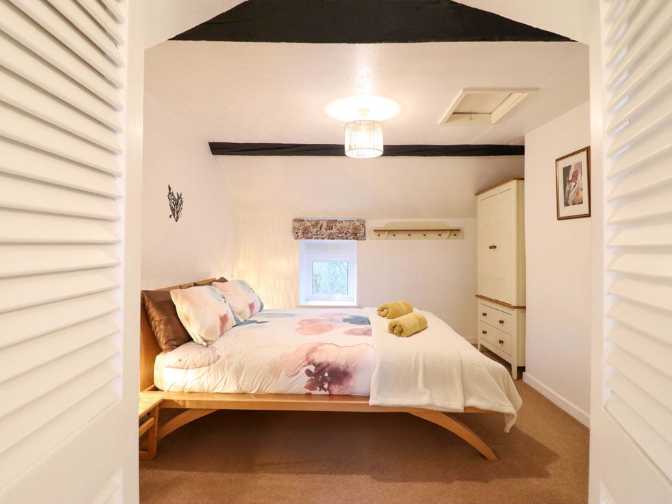 A bedroom with a bed and wardrobe at Bryn Y Garreg - The Wireless Free Farm (No Tech!) Y Trallwng