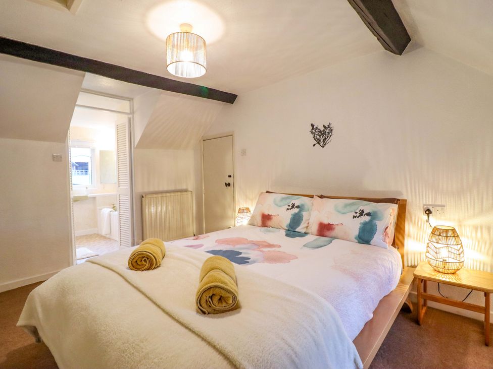 A bedroom with a bed and an adjoining bathroom at Bryn Y Garreg - The Wireless Free Farm (No Tech!) Y Trallwng