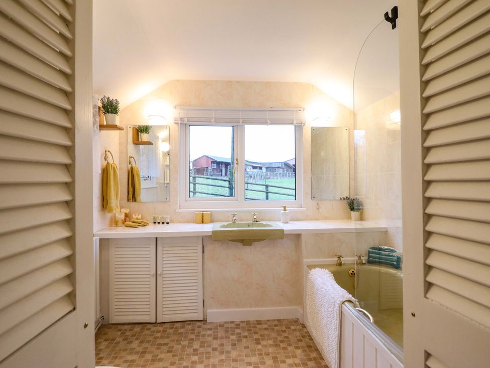 A bathroom with a sink, mirror, and shower at Bryn Y Garreg - The Wireless Free Farm (No Tech!) Y Trallwng