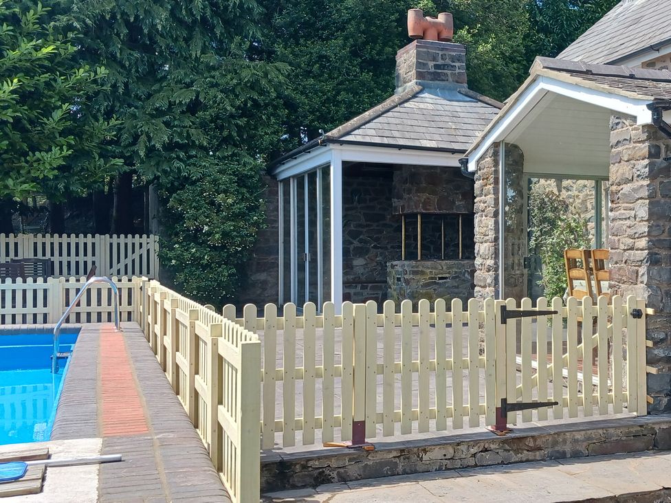 An outdoor area with a swimming pool and a fence at Bryn Y Garreg Cottage - The Wireless Free Farm, Llangadfan near Llanwddyn