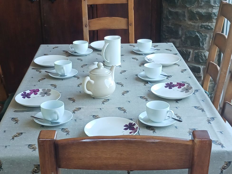 A dining room table set with cups and plates at Bryn Y Garreg Cottage - The Wireless Free Farm Llangadfan near Llanwddyn