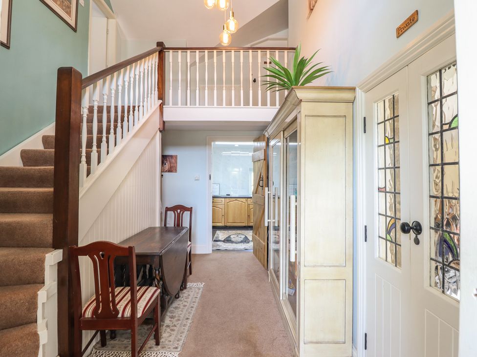 A hallway with a staircase and glass cabinet at Bryn Y Garreg Cottage - The Wireless Free Farm, Llangadfan near Llanwddyn