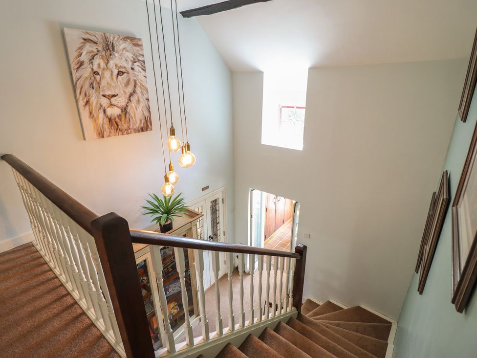 A hallway with a staircase and potted plant at Bryn Y Garreg Cottage - The Wireless Free Farm Llangadfan near Llanwddyn