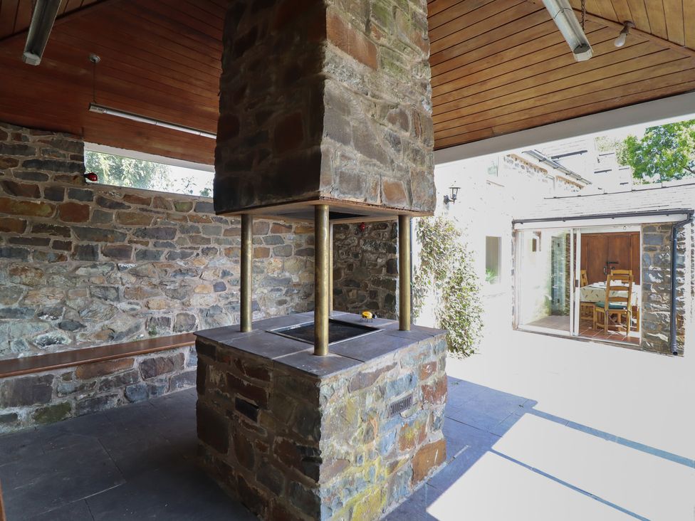 An outdoor kitchen with a stone cooking area and a support column at Bryn Y Garreg Cottage - The Wireless Free Farm, Llangadfan near Llanwddyn