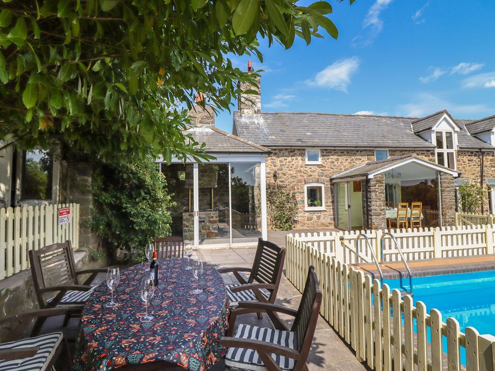An outdoor area with a table and chairs near a swimming pool at Bryn Y Garreg Cottage - The Wireless Free Farm in Llangadfan near Llanwddyn