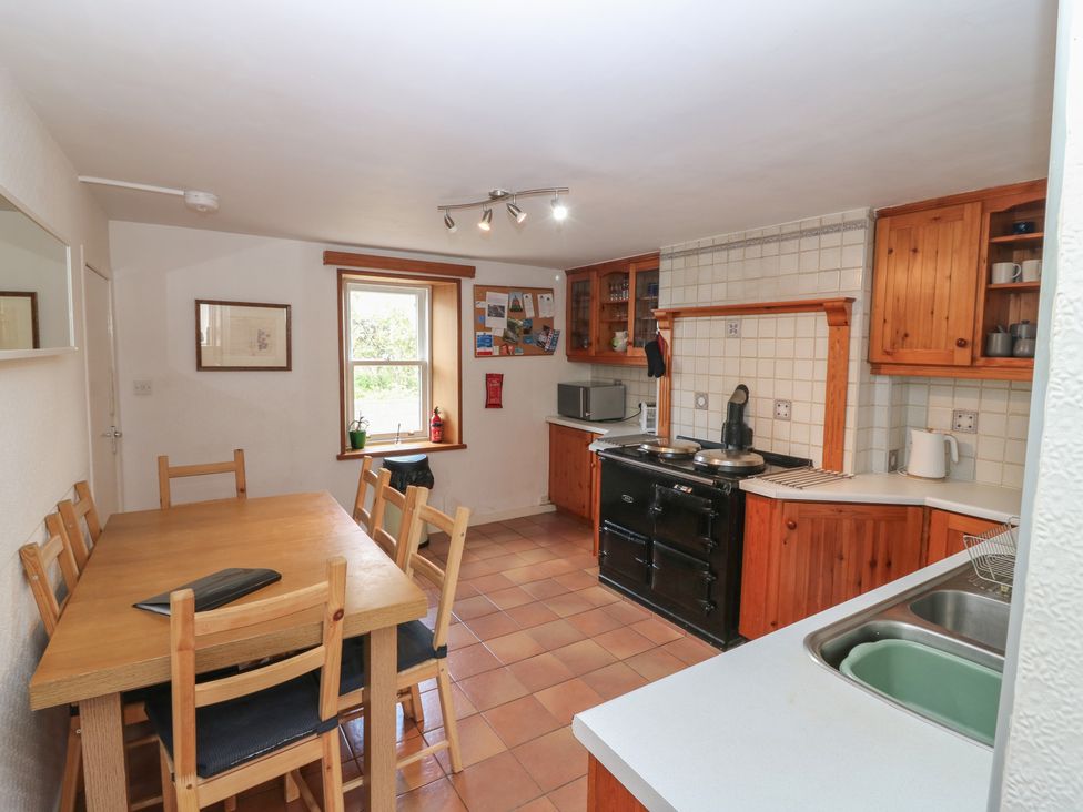 A kitchen with a dining table and stove at Footdee Cottage in Aberdeen