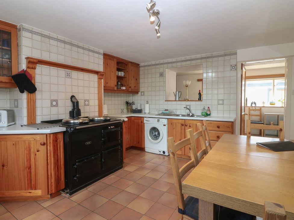 A kitchen with an Aga cooker and washing machine at Footdee Cottage in Aberdeen