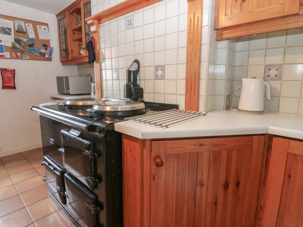 A kitchen with a stove and kettle at Footdee Cottage in Aberdeen
