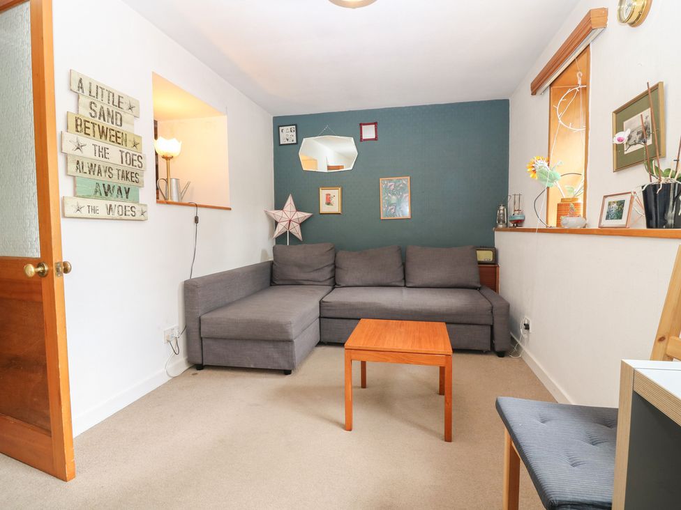 A living room with a sofa and coffee table at Footdee Cottage in Aberdeen