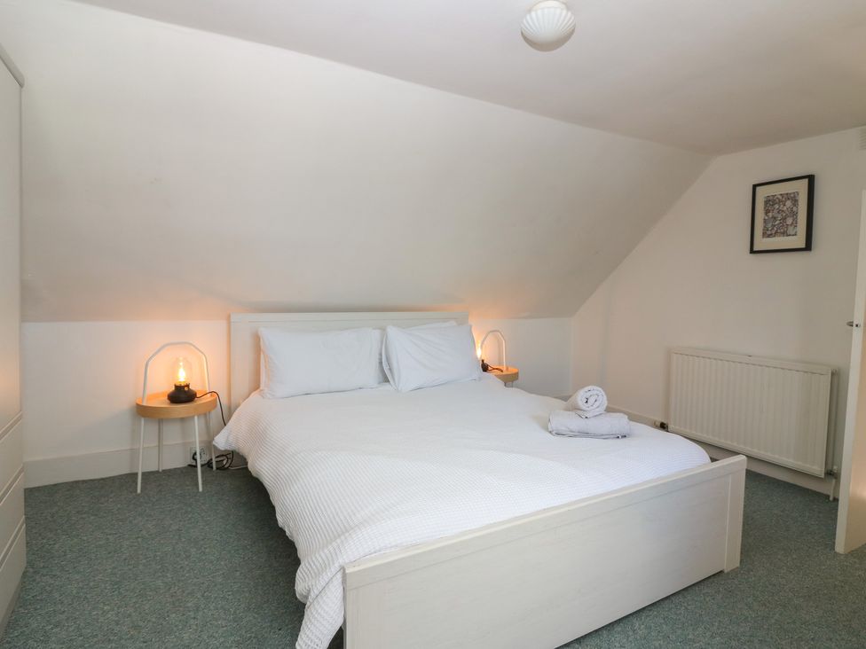 A bedroom with a bed and bedside table at Footdee Cottage in Aberdeen