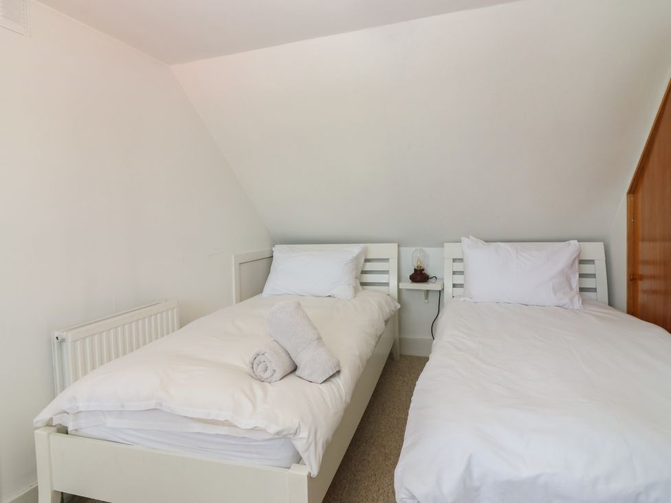 A bedroom with two beds and a radiator at Footdee Cottage in Aberdeen