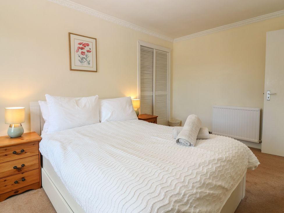 A bedroom with a bed and bedside tables at Footdee Cottage in Aberdeen