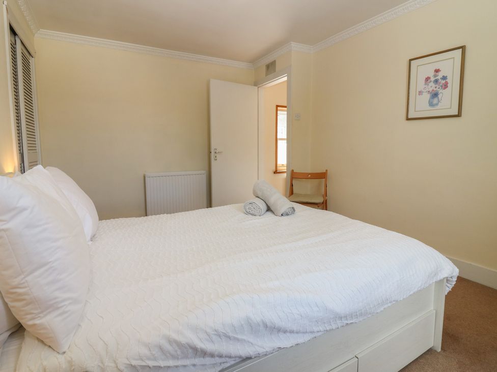A bedroom with a bed and towels at Footdee Cottage in Aberdeen