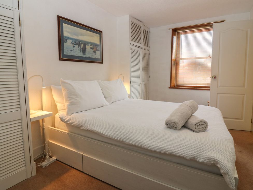A bedroom with a bed and nightstand at Footdee Cottage in Aberdeen