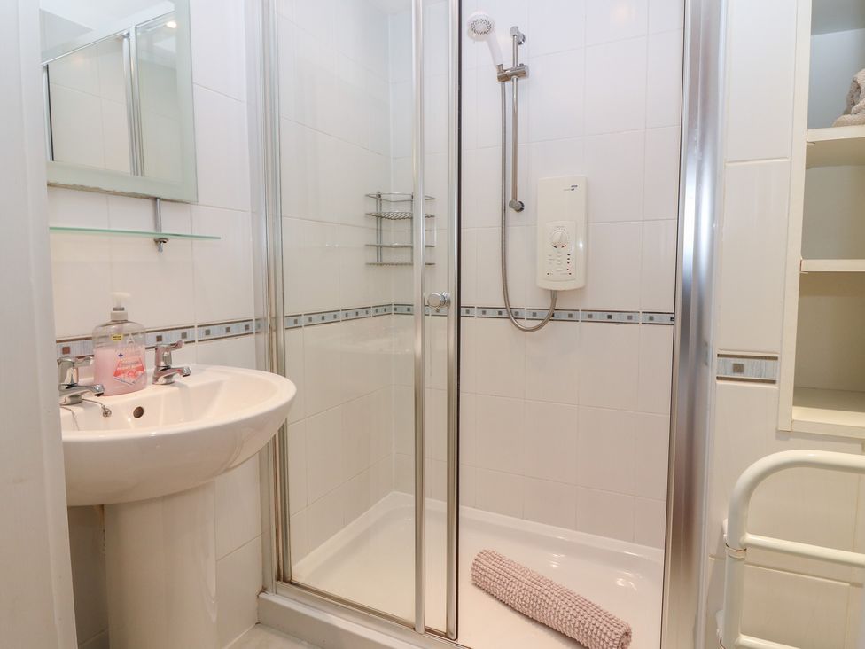 A shower with a sink in a bathroom at Footdee Cottage in Aberdeen