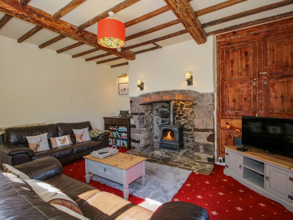 A living room with a fireplace and sofa at Beach Farmhouse in Bishops Castle