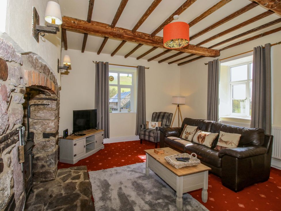 A living room with a sofa and armchair at Beach Farmhouse in Bishops Castle