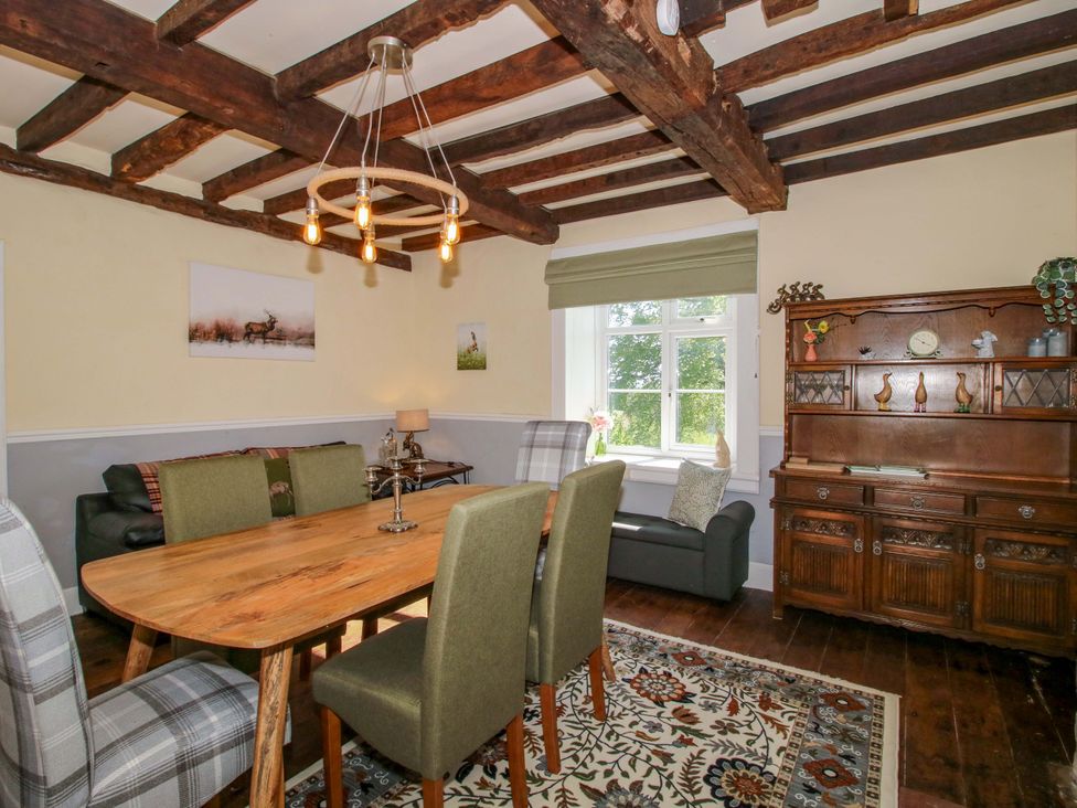 A dining room with a table and chairs at Beach Farmhouse in Bishops Castle