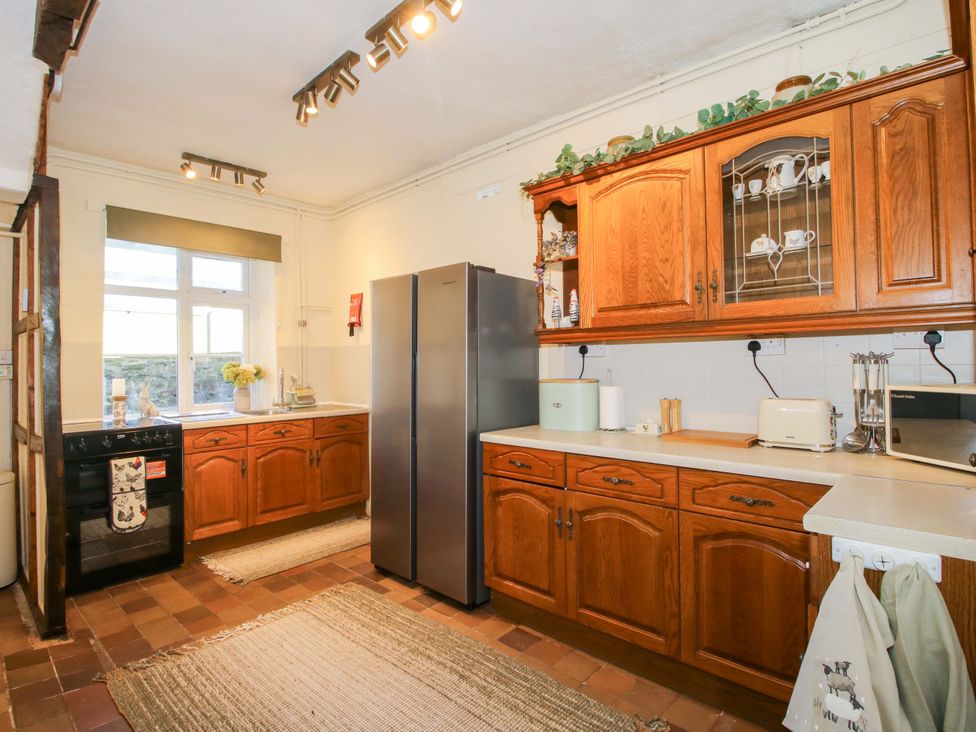 A kitchen with cabinets and appliances at Beach Farmhouse in Bishops Castle