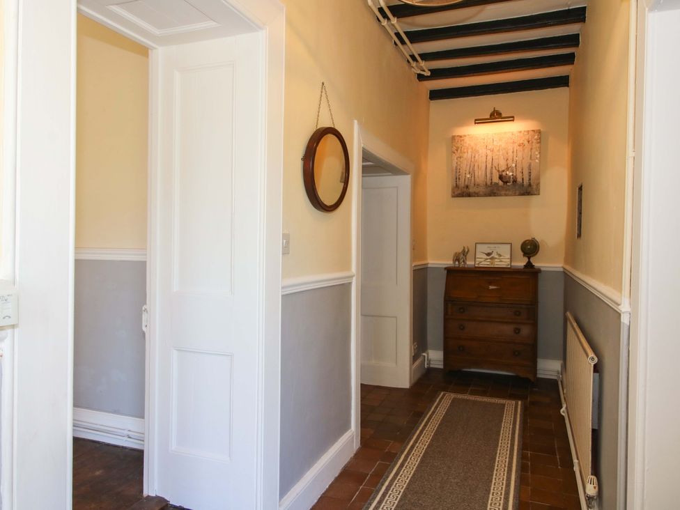 A hallway with a chest of drawers and a mirror at Beach Farmhouse in Bishops Castle