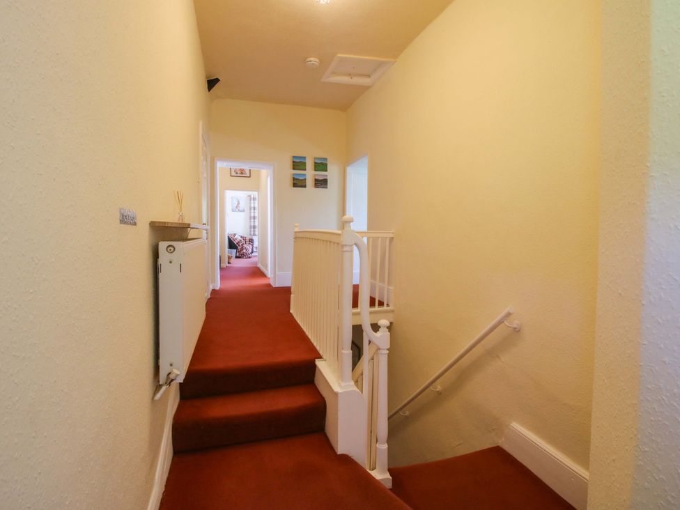 A hallway with a staircase and heat radiator at Beach Farmhouse in Bishops Castle