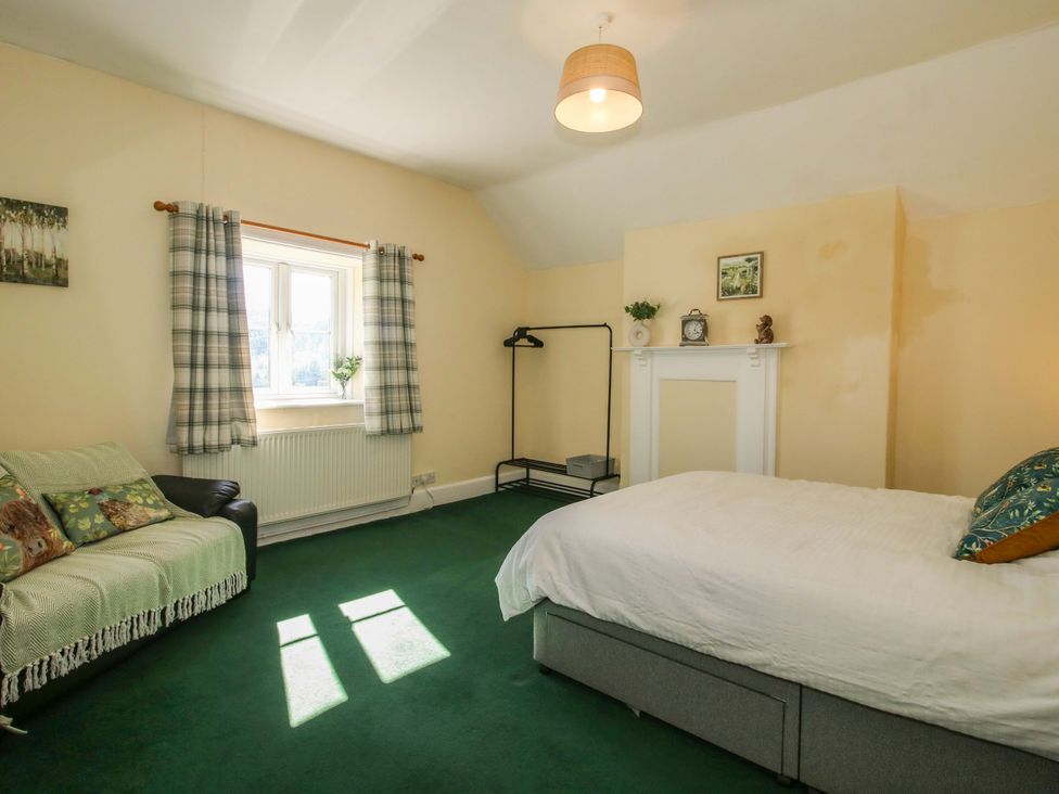 A bedroom with bed and sofa at Beach Farmhouse in Bishops Castle