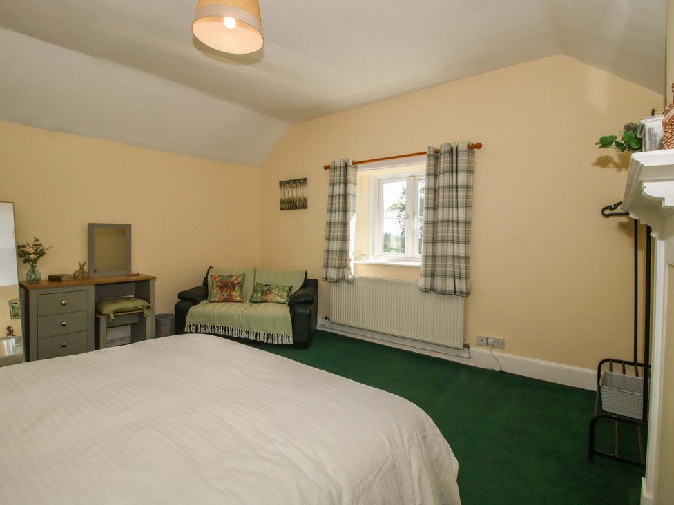 A bedroom with a bed and couch at Beach Farmhouse in Bishops Castle
