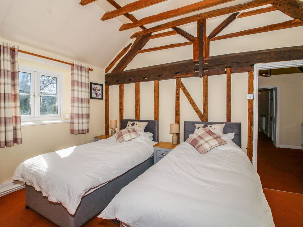 A bedroom with two single beds and a window at Beach Farmhouse in Bishops Castle