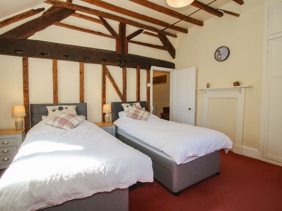A bedroom with two single beds and wooden beams at Beach Farmhouse in Bishops Castle