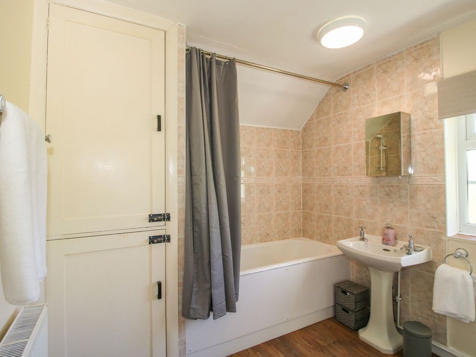 A bathroom with a bathtub and sink at Beach Farmhouse in Bishops Castle