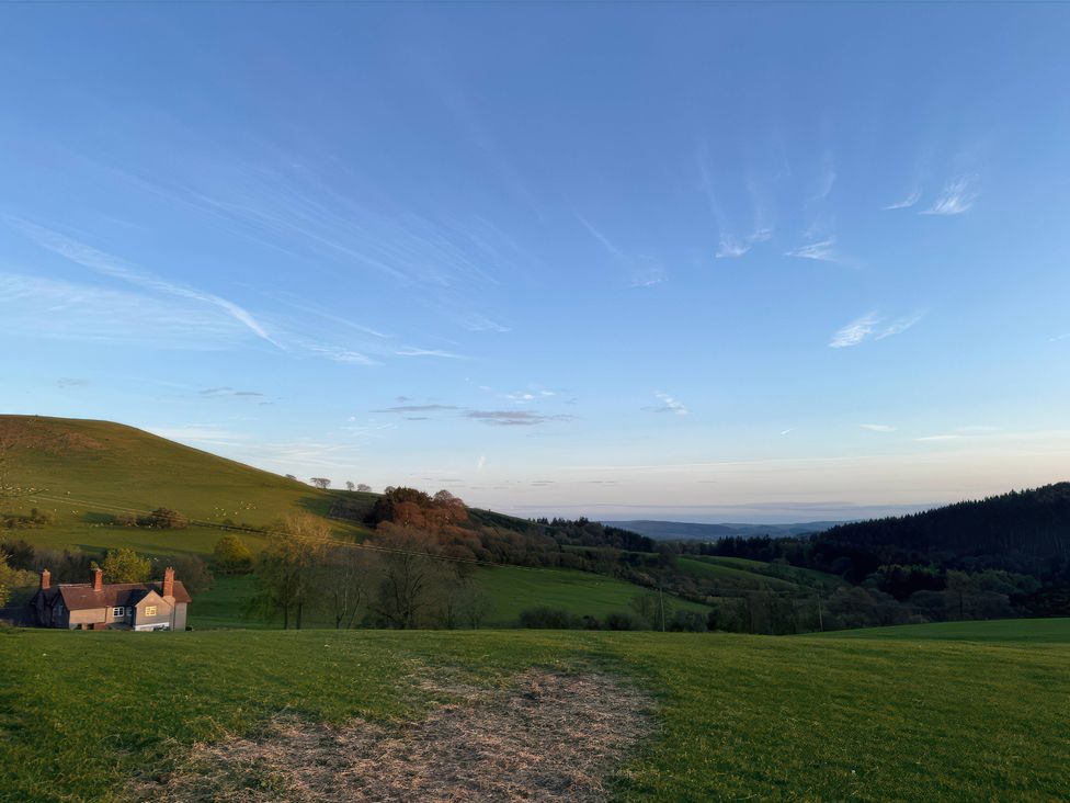 A house and hills under a clear sky at Beach Farmhouse near Bishop's Castle