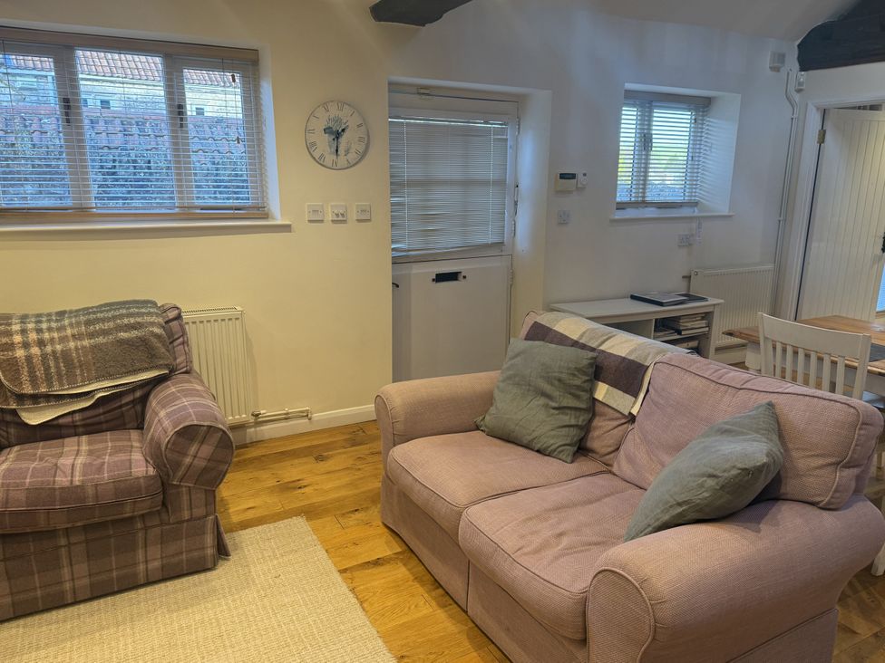 A living room with a sofa and armchair at The Forge Marksbury near Farmborough