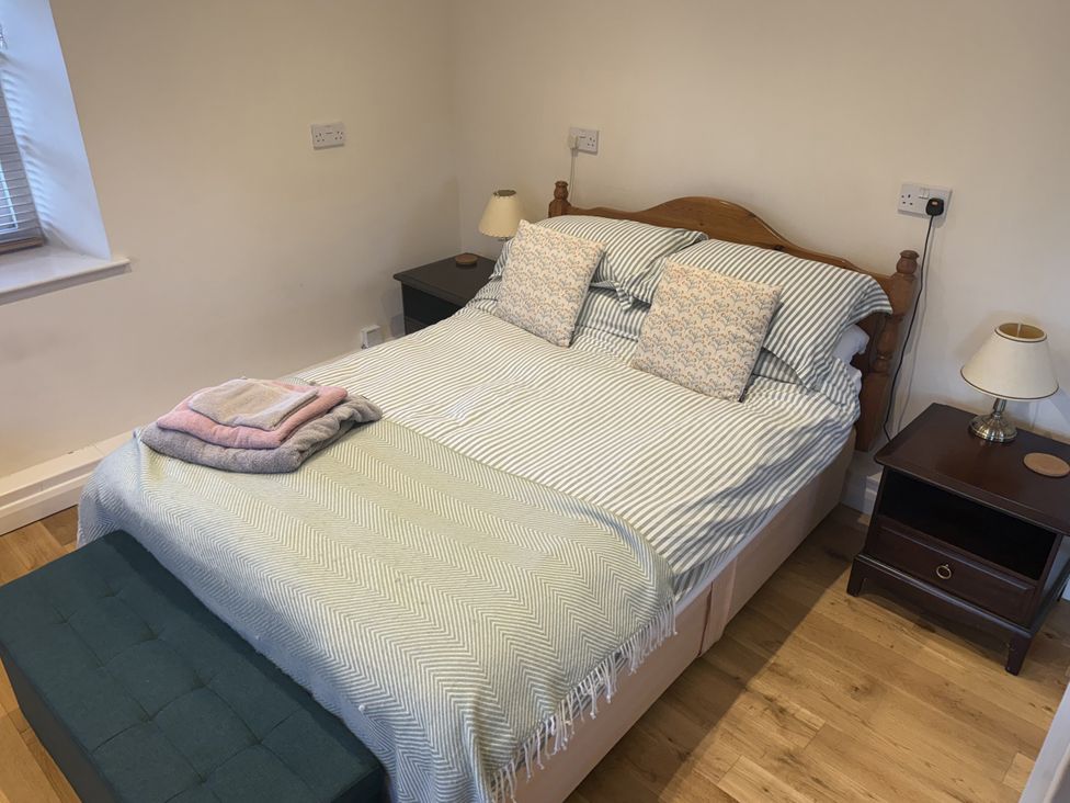 A bedroom with a bed and nightstand at The Forge in Marksbury near Farmborough