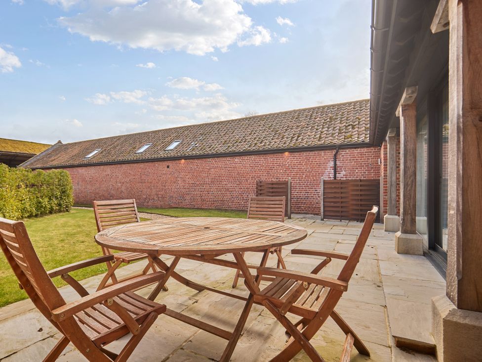 An outdoor seating area with a table and chairs at The Saddlery in Norwich