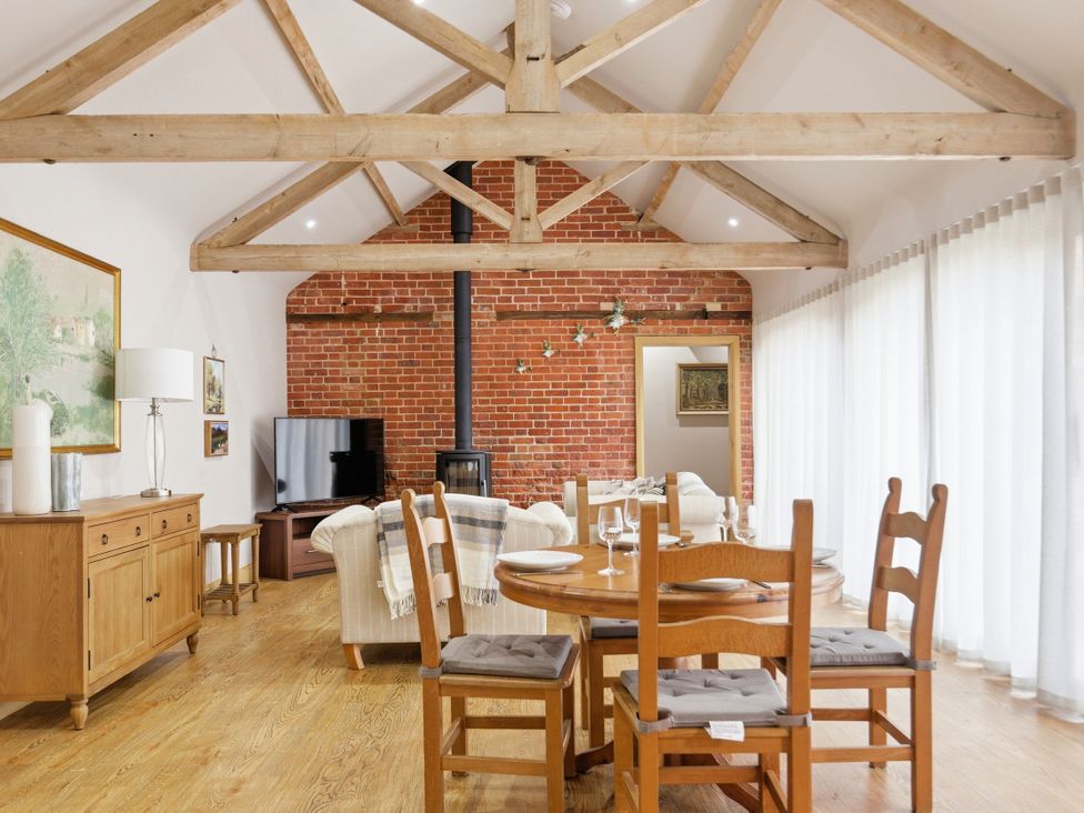 A living room with a sofa and dining area at The Saddlery in Norwich