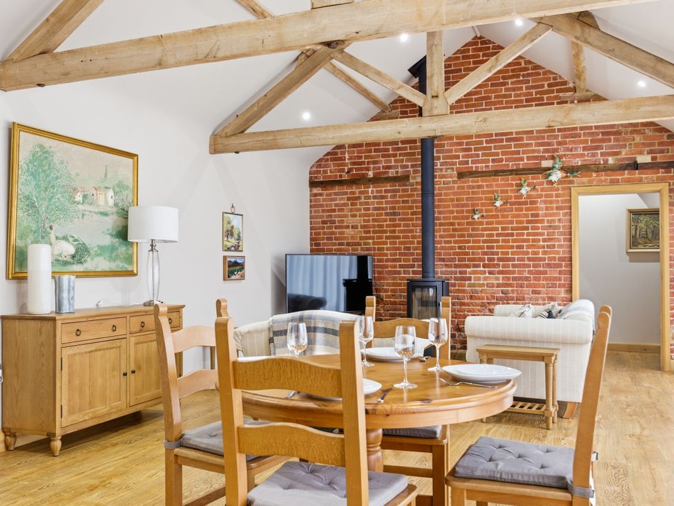 A living room with a dining table and sofa at The Saddlery in Norwich