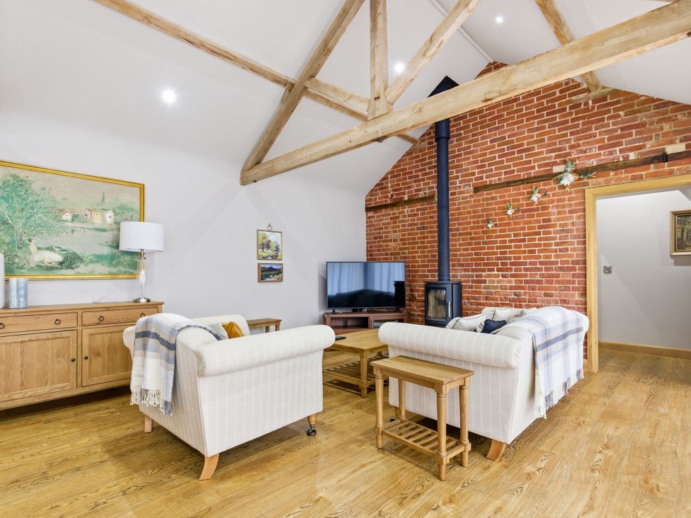 A living room with a sofa and a television at The Saddlery in Norwich