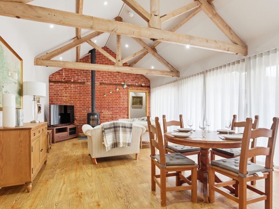 A living room with wooden beams and a dining table at The Saddlery in Norwich