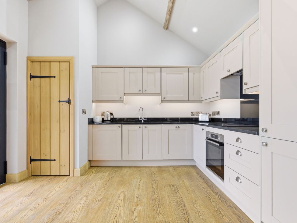 A kitchen with cabinets and appliances at The Saddlery in Norwich