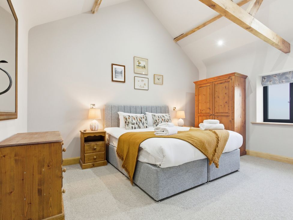 A bedroom with a double bed and wooden furniture at The Saddlery in Norwich