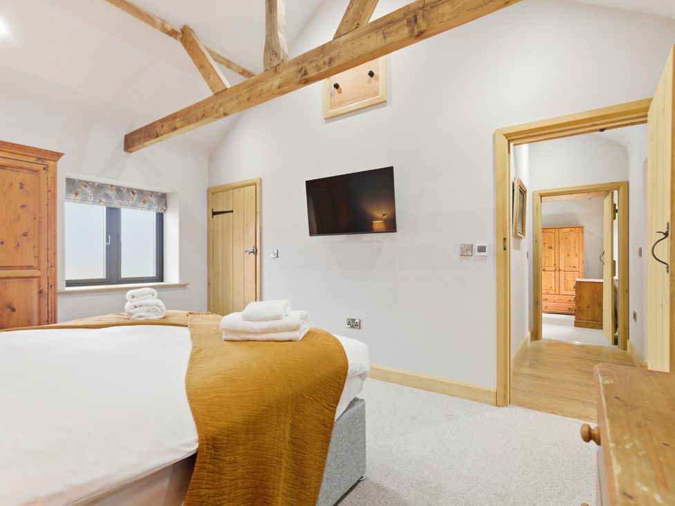 A bedroom with a bed, tv, and wardrobe at The Saddlery in Norwich