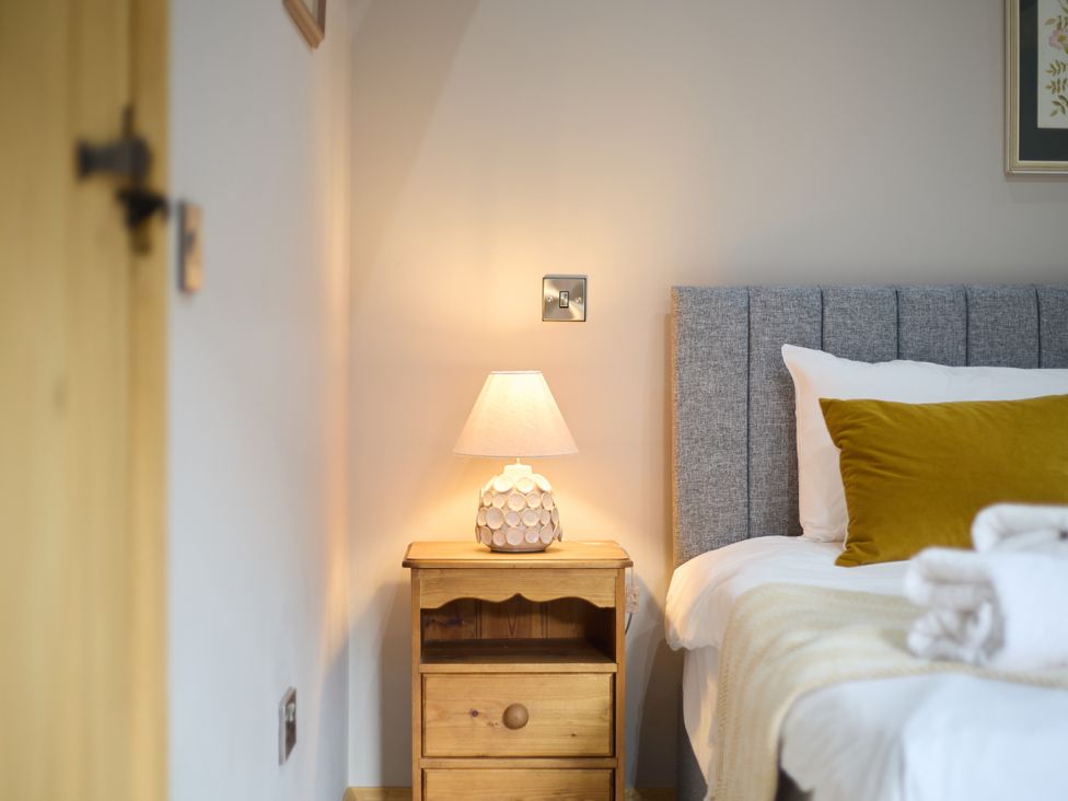 A bedroom with a bedside table and lamp at The Saddlery in Norwich