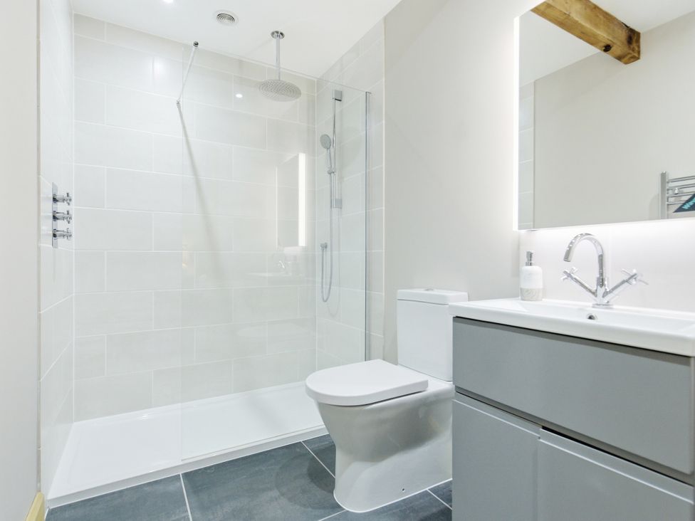 A bathroom with a shower, toilet, and sink at The Saddlery in Norwich