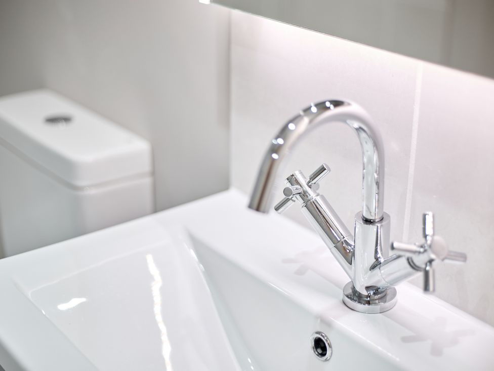 A sink with a faucet and a toilet at The Saddlery in Norwich