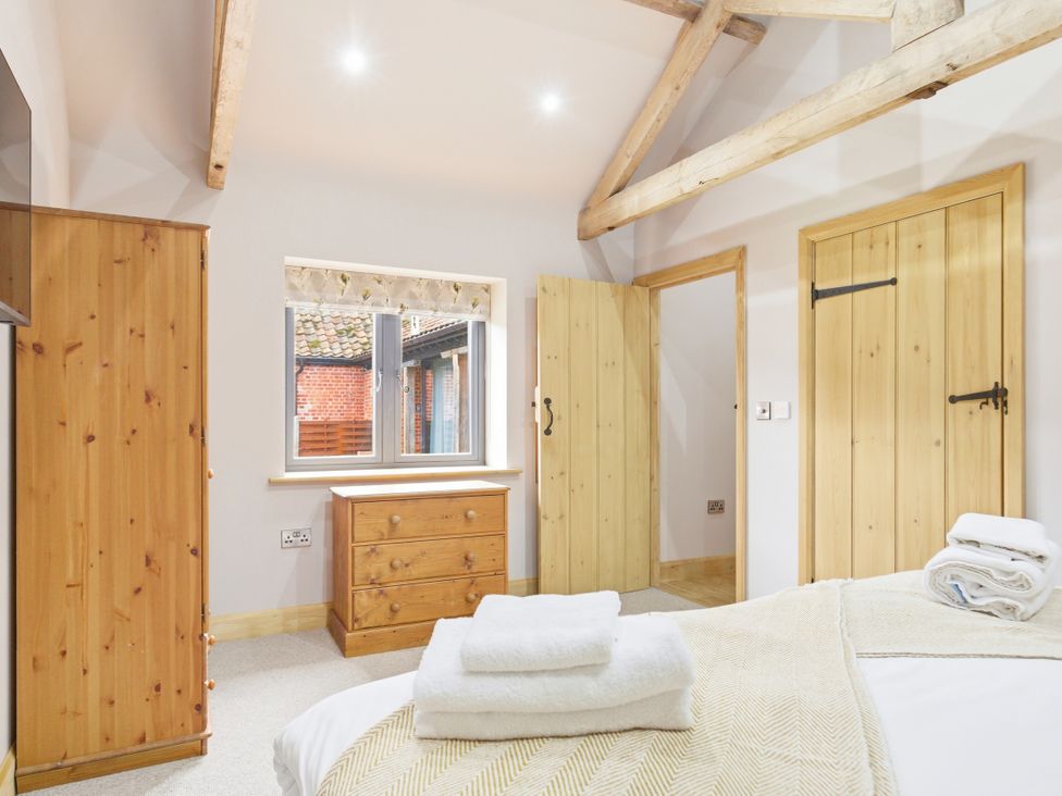 A bedroom with wood furniture and a window at The Saddlery in Norwich
