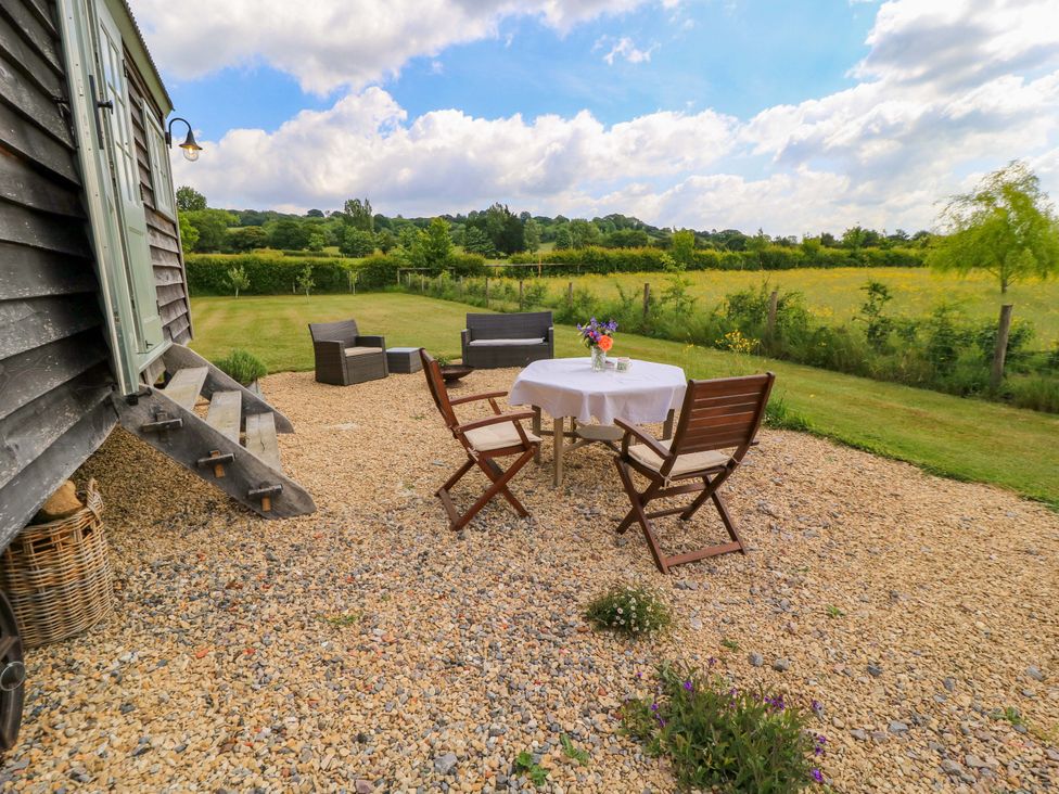 An outdoor seating area with a table and chairs at Goose Whistle Hut in Foxham